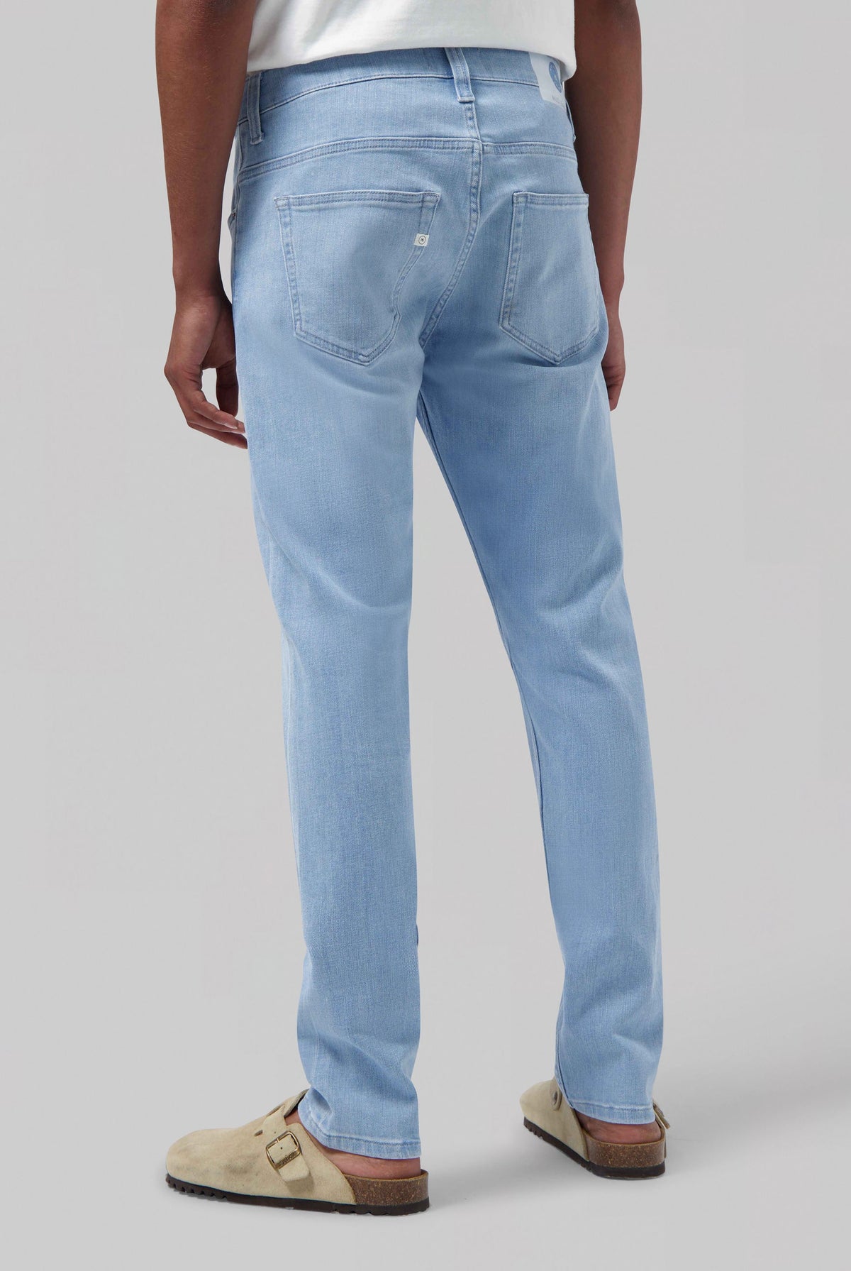 Sustainable MUD Jeans in blue denim, classic straight fit, eco-friendly and made from organic cotton, paired with white shirt.