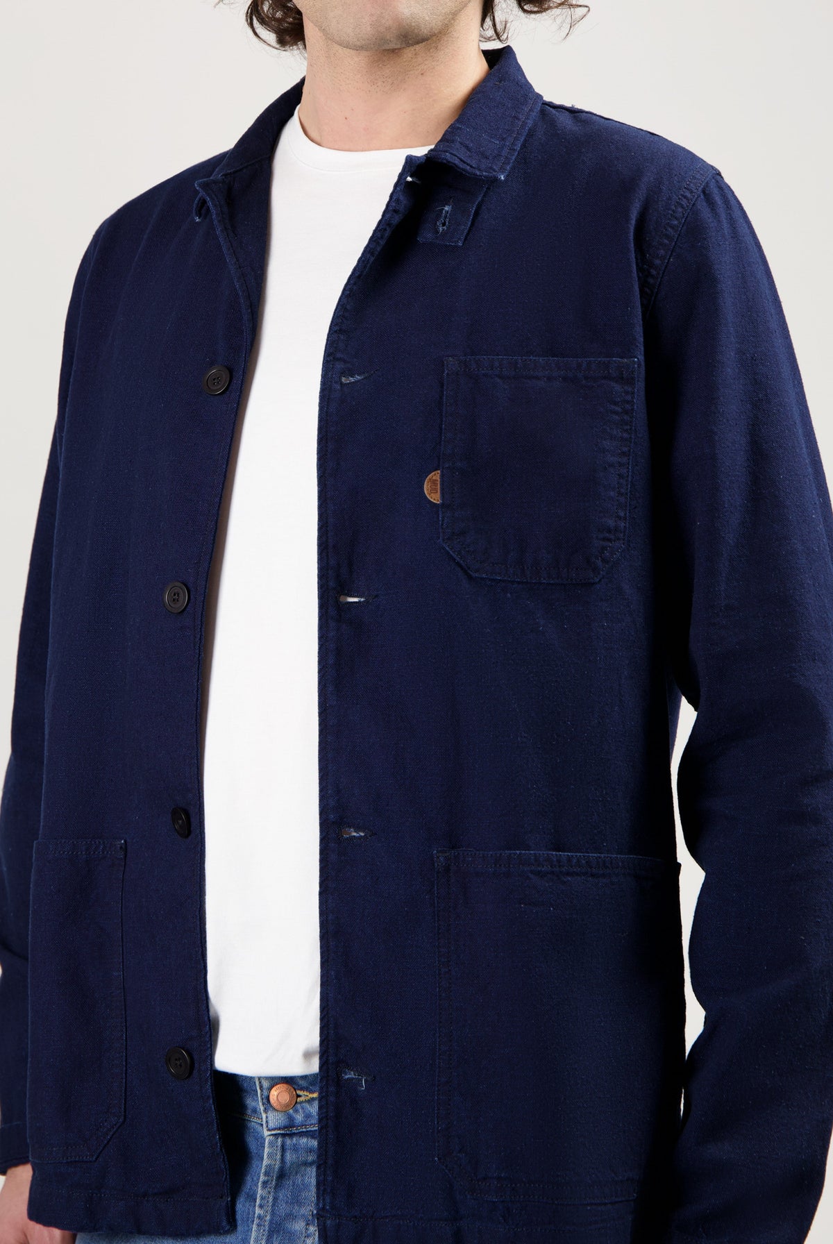 Sustainable MUD Jeans in classic blue, crafted from ethical materials, paired with a simple white tee and sneakers.