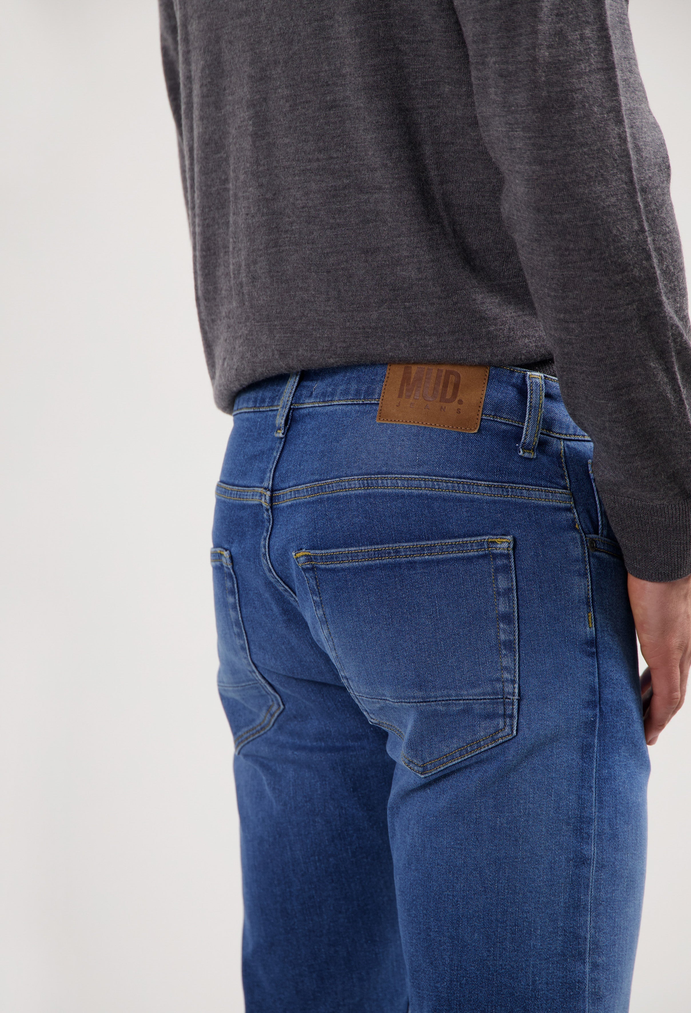 Sustainable MUD Jeans crafted from eco-friendly denim in dark blue, featuring a relaxed fit, paired with white sneakers.