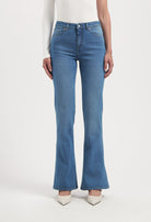 High-waisted, light blue flared jeans paired with a long-sleeve white top, showcasing a stylish casual outfit.
