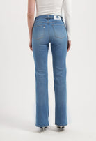 Back view of a person wearing MUD Jeans, sustainable blue denim with a straight-leg fit, paired with a simple white top.