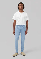 Sustainable MUD Jeans in classic blue denim, worn with a white shirt and navy sweater, showcasing ethical fashion.