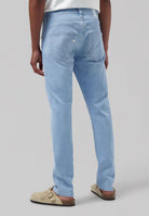 Sustainable MUD Jeans in blue denim, classic straight fit, eco-friendly and made from organic cotton, paired with white shirt.