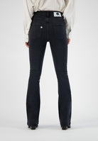 High-waisted black denim jeans by MUD, featuring a flattering fit, visible back pockets, worn with a classic white shirt.