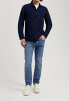 Sustainable MUD Jeans in light blue denim with a relaxed fit, paired with an ethical cream knit sweater.