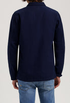 Sustainable MUD Jeans crafted from organic cotton, featuring blue denim in a relaxed fit, styled with a black jacket.