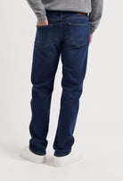 Sustainable MUD Jeans jacket and jeans in light blue denim, crafted from organic cotton, paired with white sneakers.