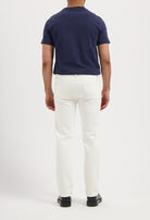 Sustainable MUD Jeans in dark indigo denim, paired with white sneakers, embodying ethical fashion.