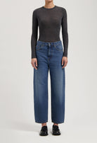 Dark gray long-sleeve top paired with high-waisted wide-leg blue jeans and black loafers, showcasing casual style.