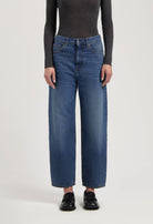 Casual high-waisted wide-leg jeans in classic blue denim paired with a fitted long-sleeve charcoal gray top and black loafers.