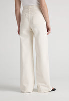 Wide-leg cream denim jeans from MUD Jeans, showing back pockets and high waist, paired with black shoes.